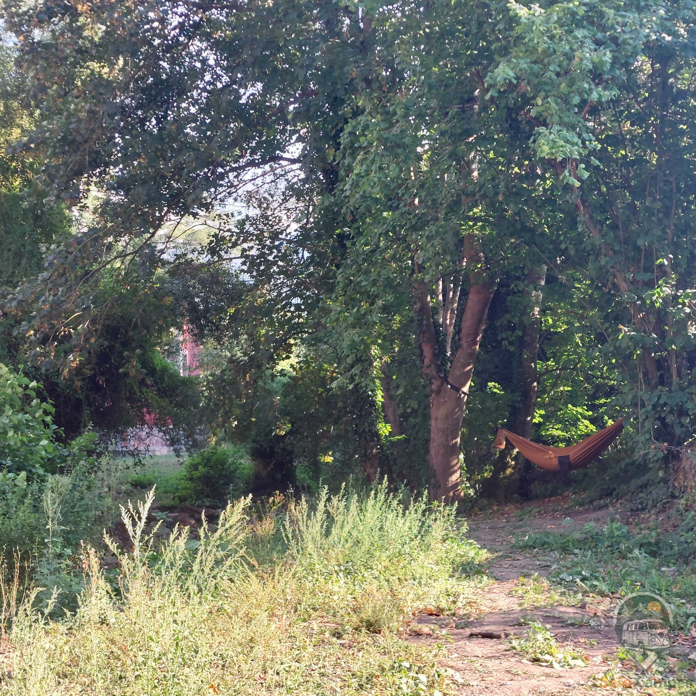 Zona de descanso natural junto al río, con hamaca